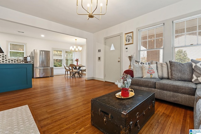 living area featuring dark wood-type flooring, baseboards, and an inviting chandelier