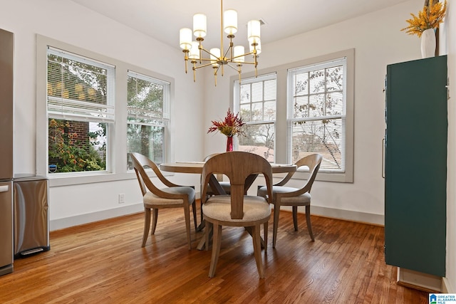 dining area with baseboards, a wealth of natural light, and wood finished floors