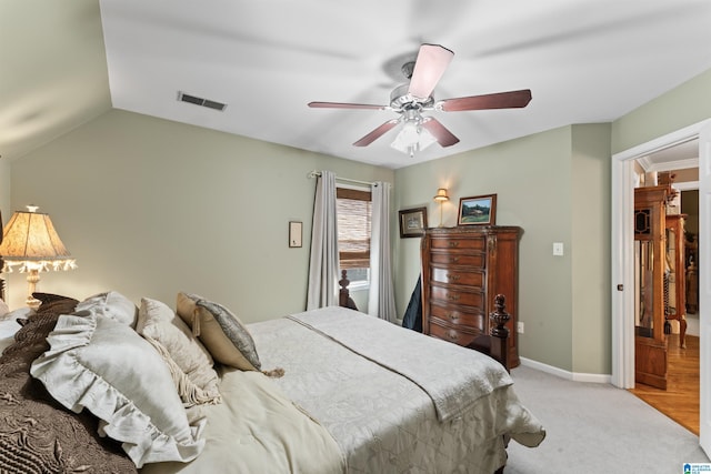 bedroom with light colored carpet, visible vents, vaulted ceiling, ceiling fan, and baseboards