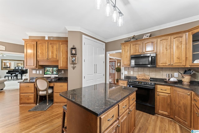 kitchen with glass insert cabinets, stainless steel microwave, a center island, decorative light fixtures, and black / electric stove