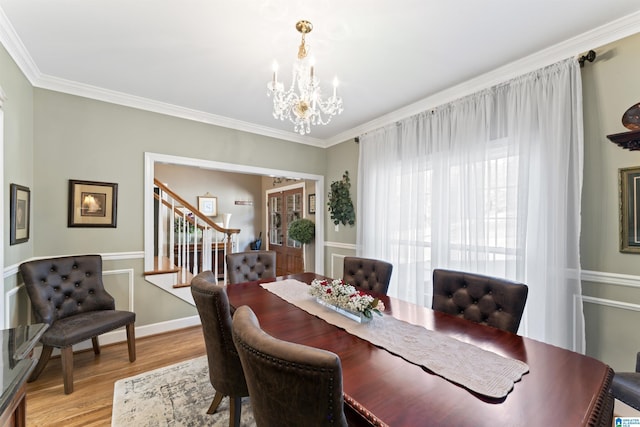 dining room featuring a chandelier, stairway, light wood-type flooring, and crown molding