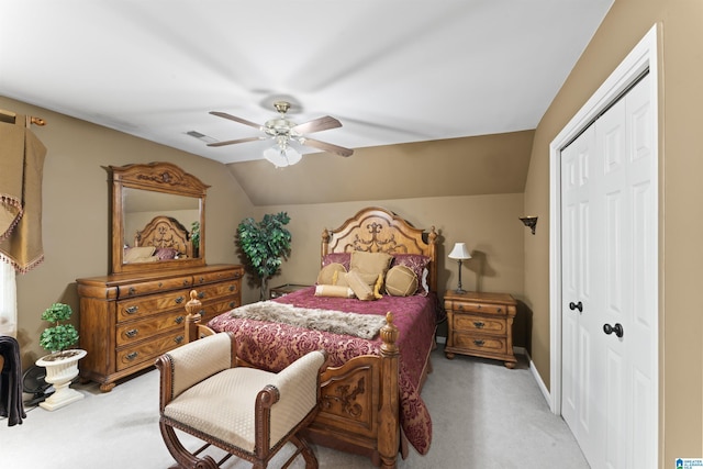 bedroom with visible vents, light colored carpet, ceiling fan, vaulted ceiling, and a closet