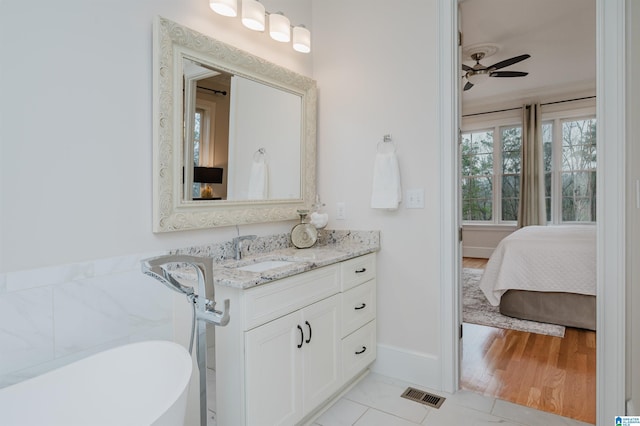 ensuite bathroom with a soaking tub, visible vents, ceiling fan, vanity, and ensuite bath