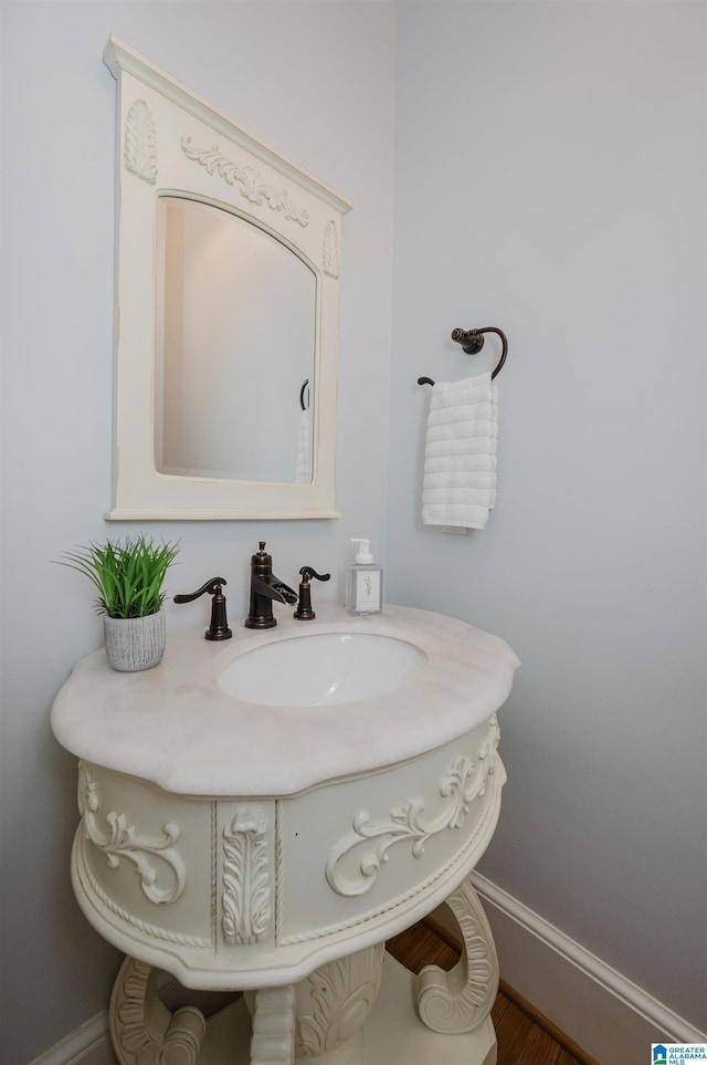 bathroom featuring baseboards and a sink