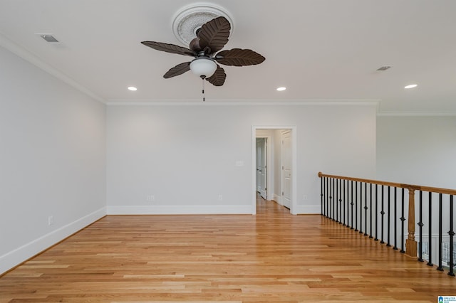 spare room with ornamental molding, light wood-type flooring, recessed lighting, and baseboards