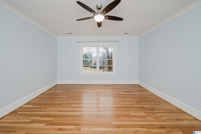 spare room with light wood-style floors, ornamental molding, and baseboards