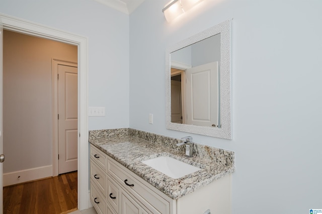 bathroom featuring vanity, baseboards, and wood finished floors