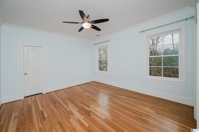 empty room featuring light wood-style floors, baseboards, ornamental molding, and ceiling fan