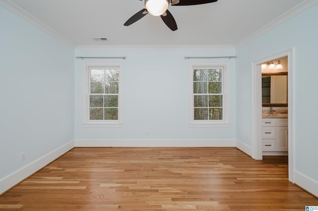 unfurnished bedroom with ornamental molding, light wood-style flooring, and baseboards