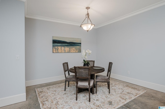 dining room featuring concrete floors, crown molding, and baseboards