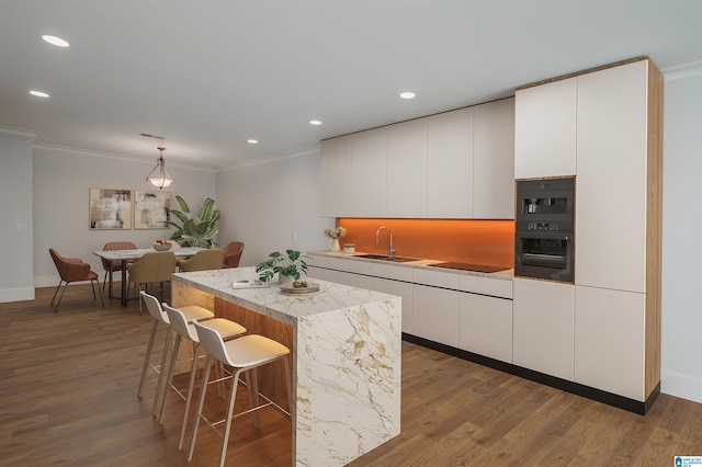 kitchen featuring a kitchen island, white cabinetry, hanging light fixtures, black appliances, and modern cabinets