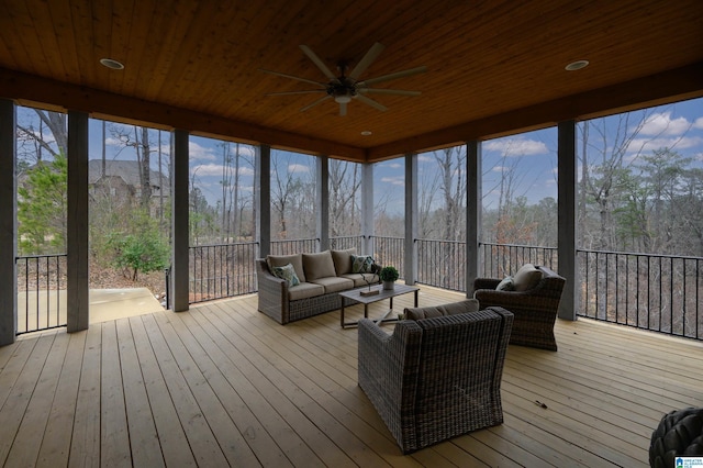 sunroom / solarium featuring a healthy amount of sunlight, wood ceiling, and a ceiling fan