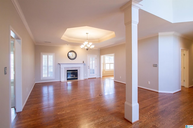 unfurnished living room featuring ornate columns, a tray ceiling, dark wood-type flooring, and a high end fireplace