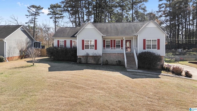 ranch-style home with a porch, fence, stairway, and a front lawn