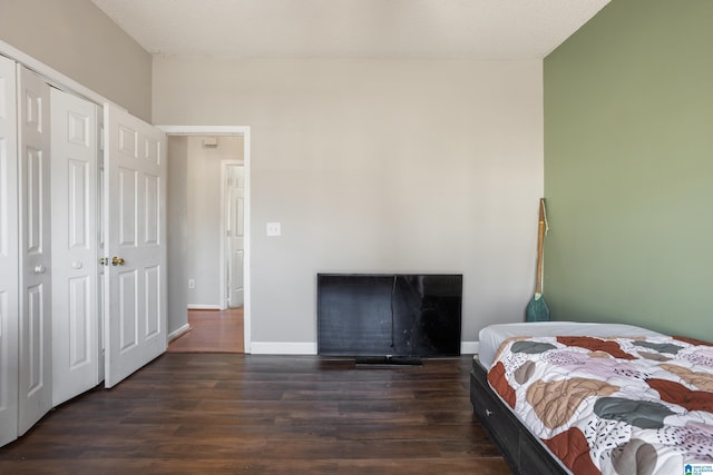 bedroom featuring baseboards and dark wood-type flooring