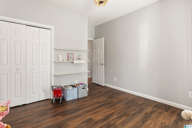 bedroom with a closet, dark wood finished floors, and baseboards