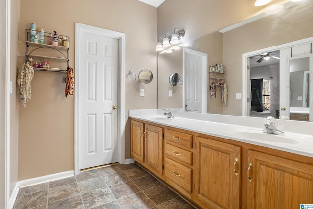 full bath featuring double vanity, a sink, and baseboards