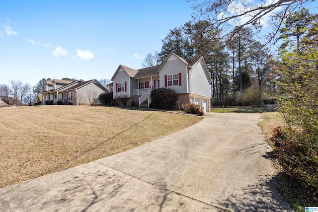 single story home featuring a garage, a front yard, concrete driveway, and brick siding