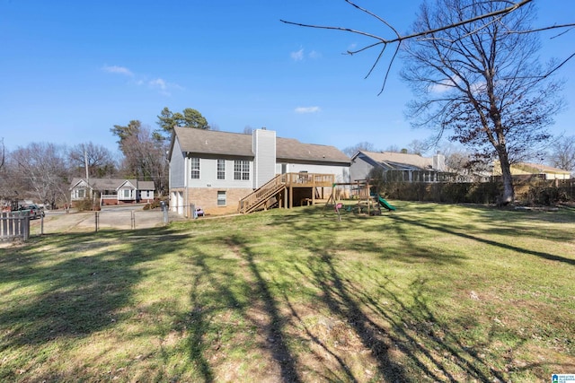 back of property with a lawn, a fenced backyard, a chimney, a gate, and a playground