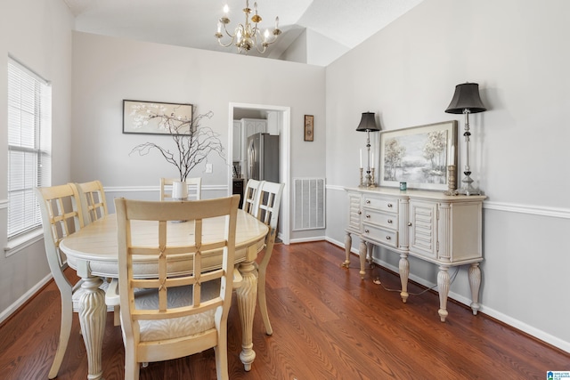 dining room with a chandelier, wood finished floors, visible vents, and baseboards