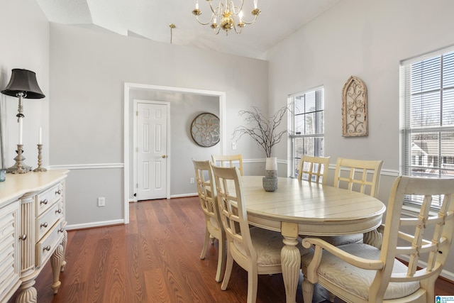 dining room featuring baseboards, vaulted ceiling, dark wood finished floors, and a notable chandelier