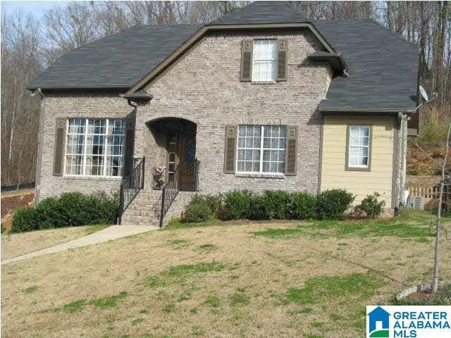 view of front facade with a front yard and brick siding