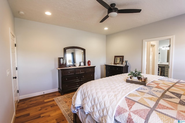 bedroom featuring a textured ceiling, baseboards, dark wood-style flooring, and recessed lighting