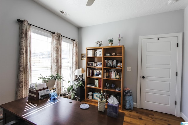 office area featuring dark wood finished floors, a textured ceiling, baseboards, and ceiling fan