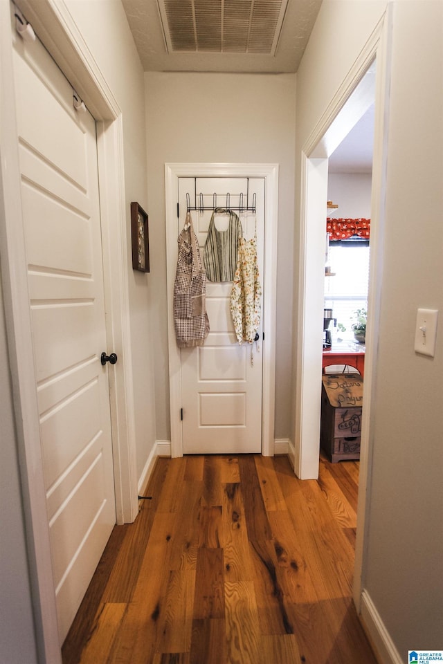 doorway featuring baseboards, visible vents, and dark wood-style flooring