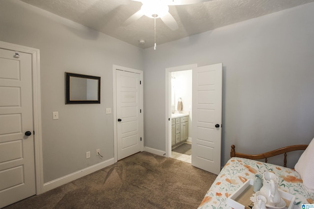 carpeted bedroom featuring a ceiling fan, ensuite bath, baseboards, and a textured ceiling