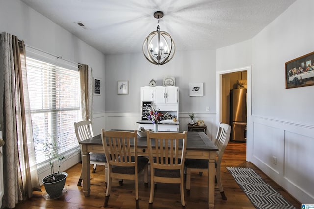 dining room featuring a wainscoted wall, dark wood-style flooring, and a healthy amount of sunlight