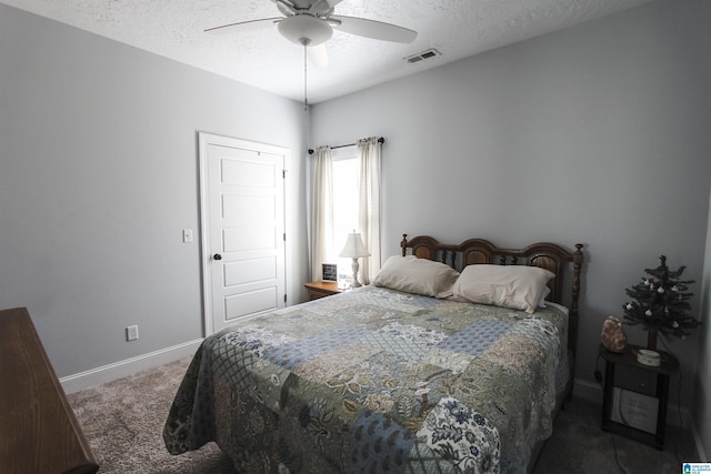 bedroom featuring baseboards, visible vents, a ceiling fan, dark colored carpet, and a textured ceiling