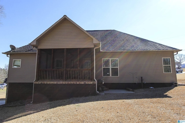 rear view of property with crawl space, roof with shingles, and a sunroom