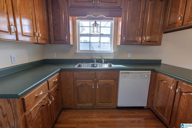 kitchen featuring a sink, dark countertops, dark wood-style flooring, and dishwasher