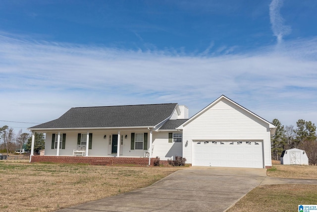 single story home with covered porch, a garage, driveway, a shed, and a front yard