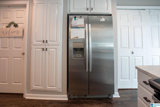 kitchen featuring light countertops, white cabinets, stainless steel fridge, and dark wood finished floors