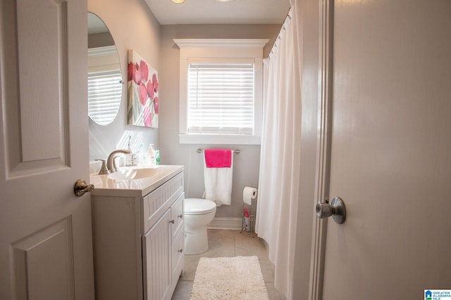 full bath featuring tile patterned flooring, baseboards, vanity, and toilet