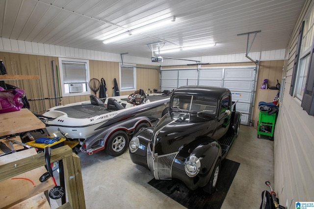 garage featuring metal wall, cooling unit, and a garage door opener