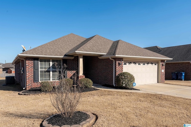 single story home with a garage, a shingled roof, concrete driveway, a front lawn, and brick siding