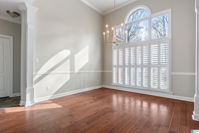 empty room featuring ornate columns, crown molding, baseboards, and dark wood-type flooring