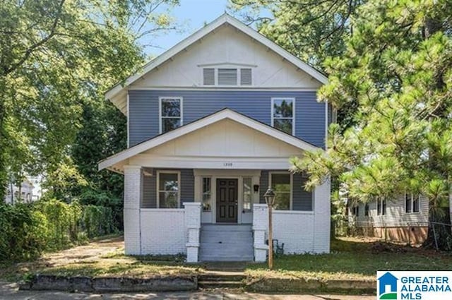 traditional style home with covered porch and brick siding