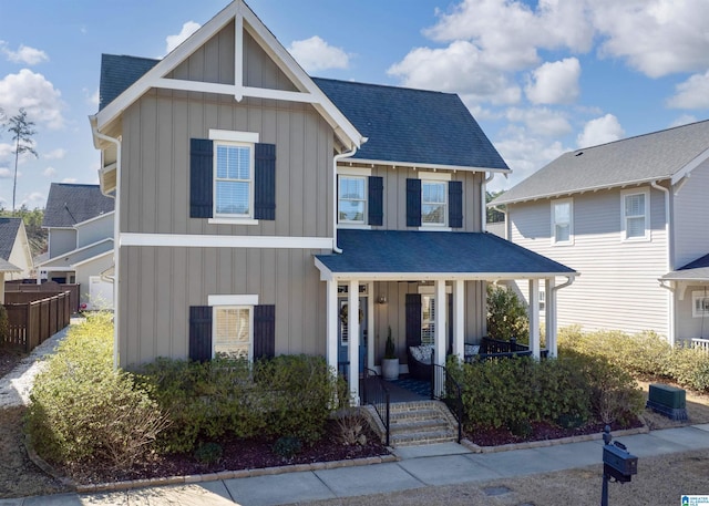 view of front of house featuring fence, a porch, board and batten siding, and roof with shingles