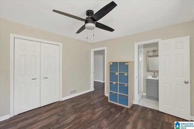 unfurnished bedroom with dark wood-type flooring, a closet, and baseboards