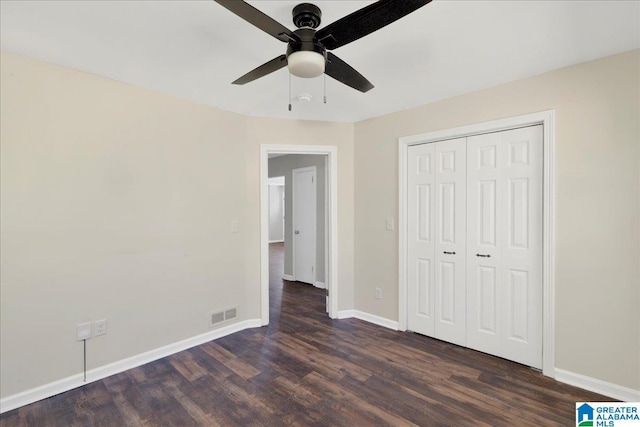 unfurnished bedroom featuring a ceiling fan, visible vents, baseboards, a closet, and dark wood finished floors