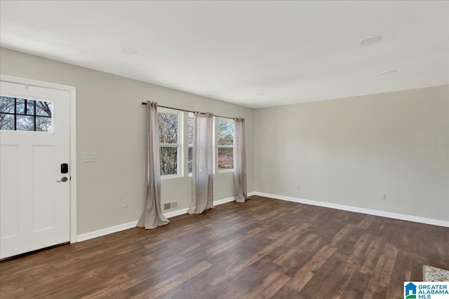 foyer entrance with dark wood-style flooring, visible vents, and baseboards