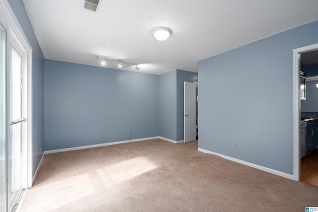 unfurnished room with baseboards, visible vents, and light colored carpet