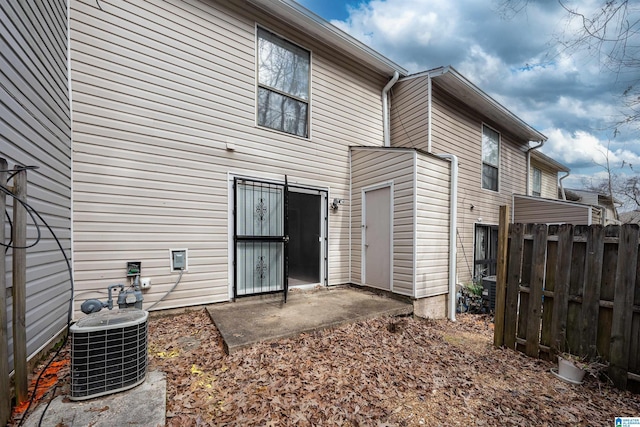 rear view of house featuring fence, central AC, and a patio