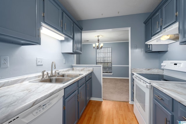 kitchen with under cabinet range hood, white appliances, a sink, light countertops, and decorative light fixtures