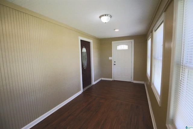 doorway with dark wood-style flooring and baseboards