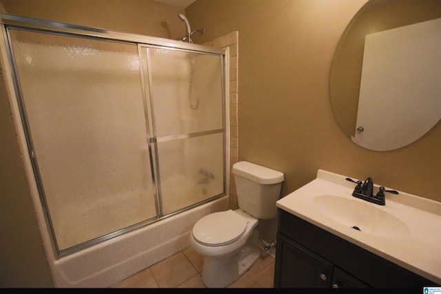 full bathroom featuring tile patterned flooring, enclosed tub / shower combo, vanity, and toilet